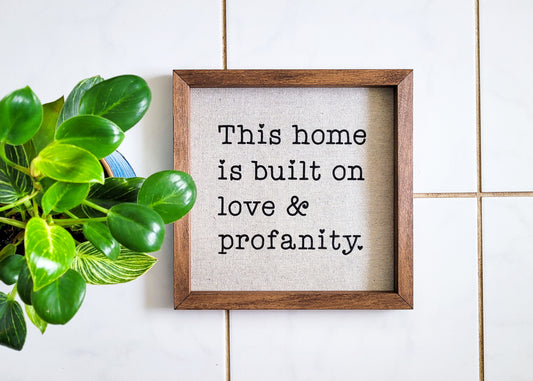 This home is built on love & profanity - reverse canvas sign