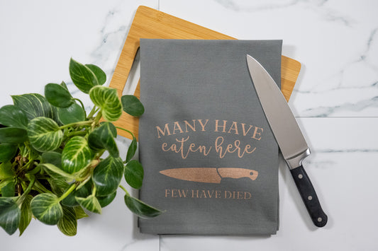 Many Have Eaten Here, Few Have Died Gray Tea Towel with Rose Gold Ink