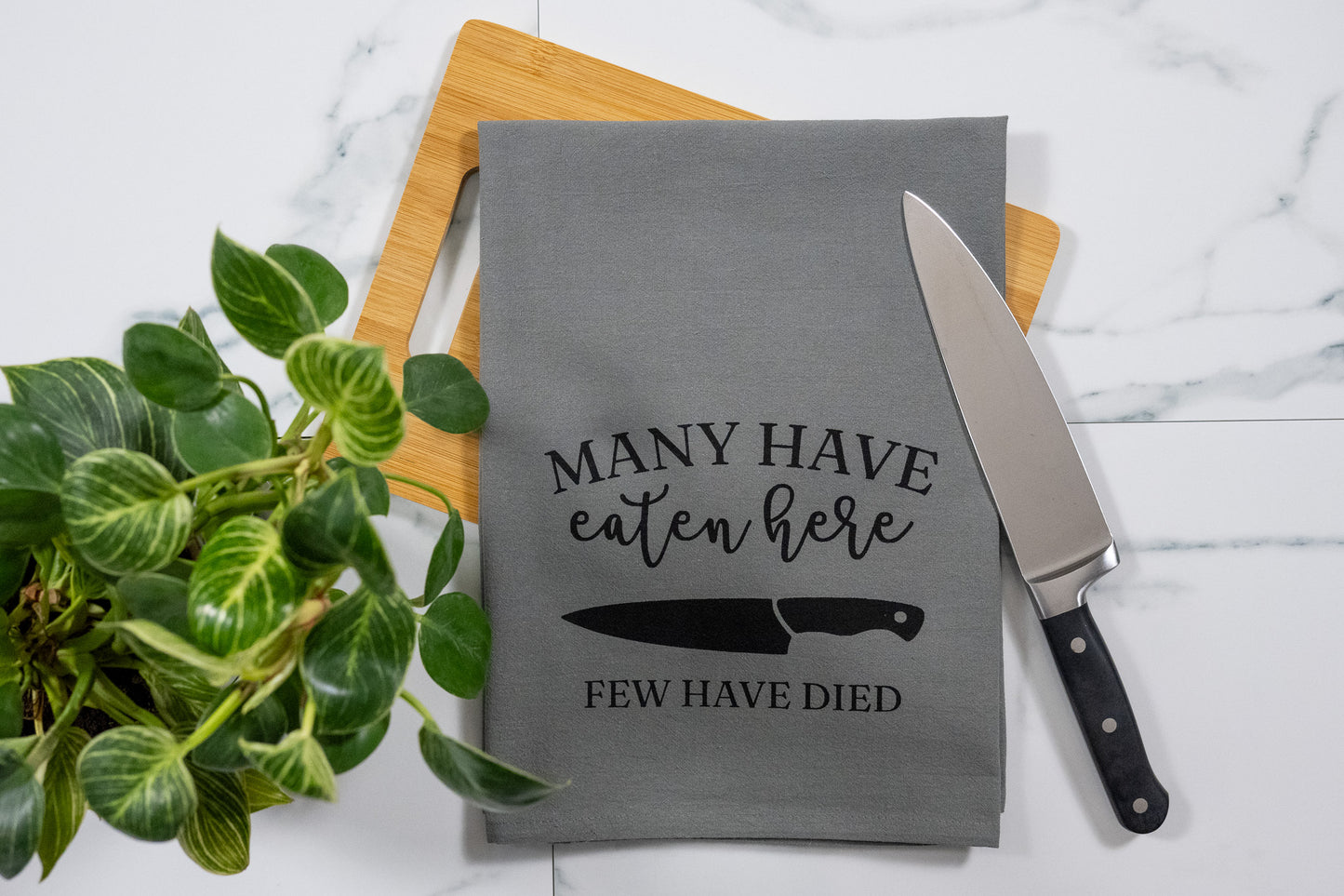Many Have Eaten Here, Few Have Died Gray Tea Towel with Black Ink