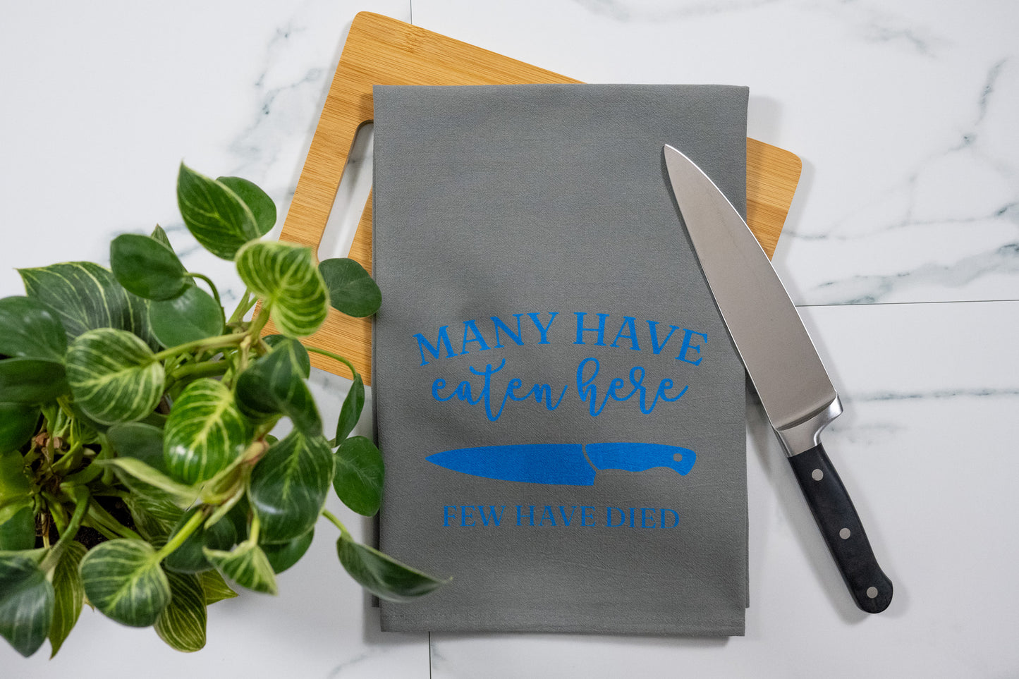 Many Have Eaten Here, Few Have Died Gray Tea Towel with Electric Blue Ink