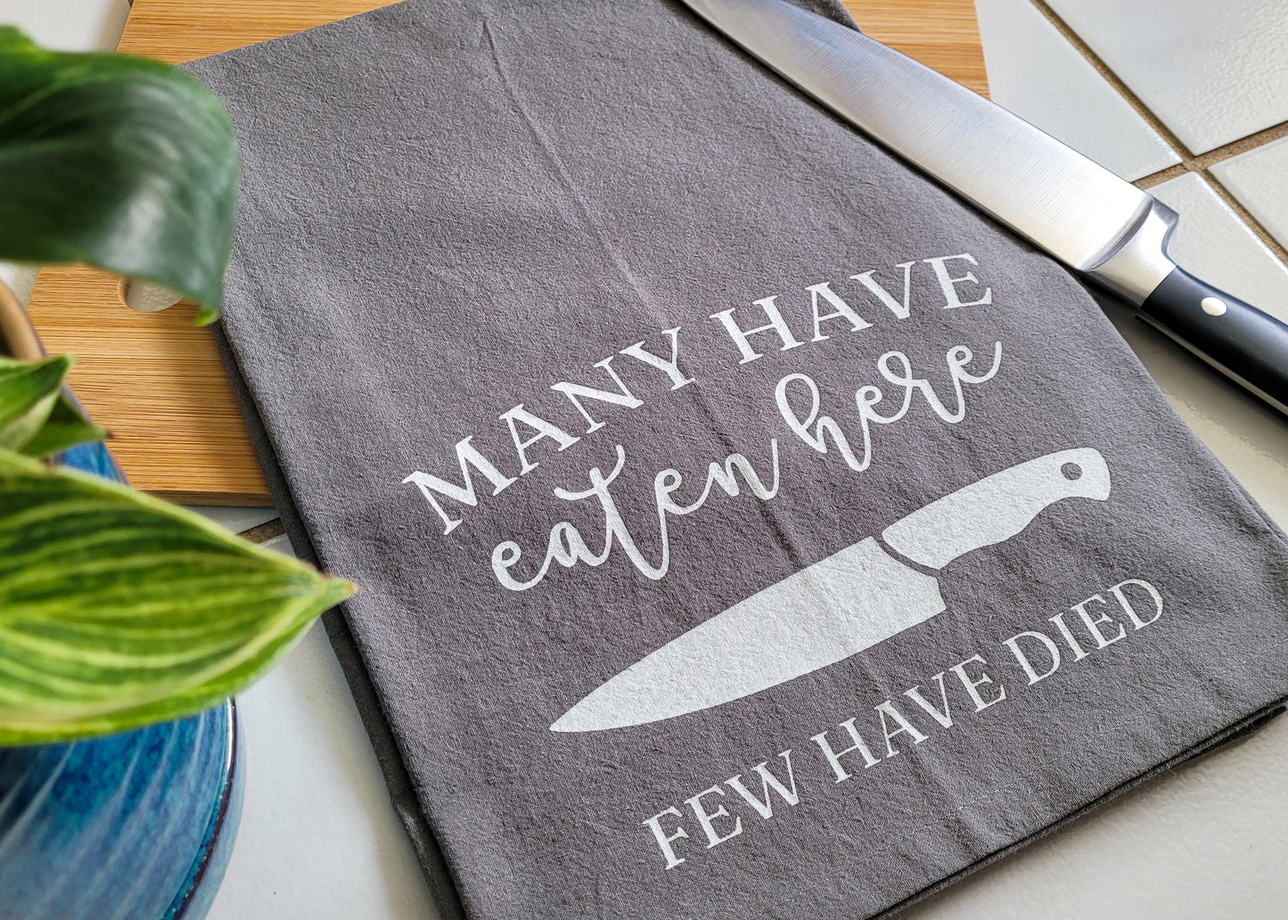 Many Have Eaten Here, Few Have Died Tea Towel - Gray